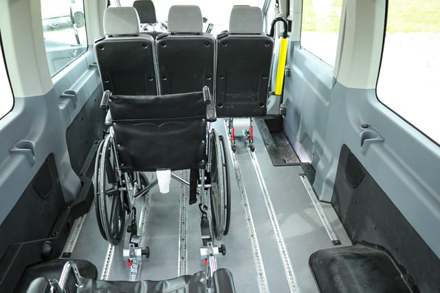 wheelchair restraints holding down a wheelchair in a Ford Transit accessible mobility van for disabled transportation