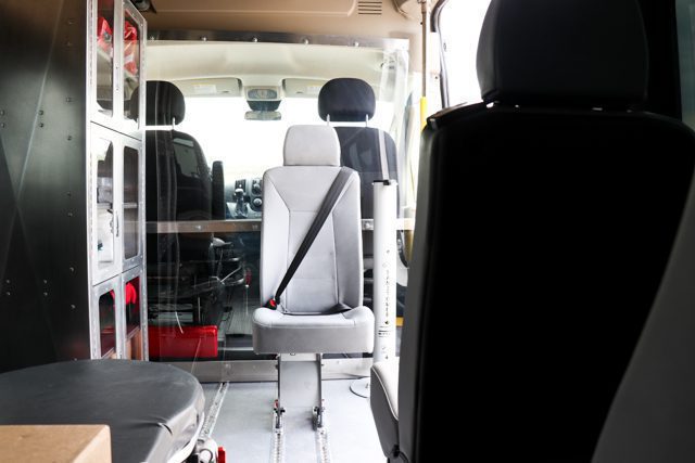 rear-facing attendant seat near medical cabinet in van
