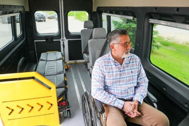 Person in wheelchair in a P4 3-in-1 Accessible Patient Transfer Van from MoveMobility for gurney transportation