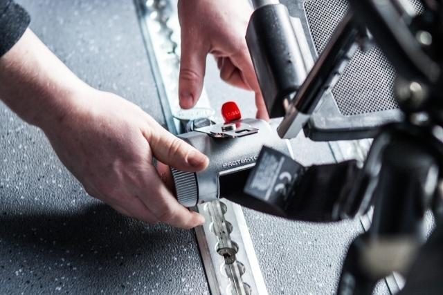 Wheelchair restraints being attached to AutoFloor in a wheelchair van