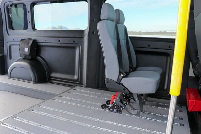 Side door entrance of VL Series wheelchair van with grab handle and two removable seats